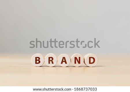 Wood cube block with word BRAND on wooden table. Brand building for success concept