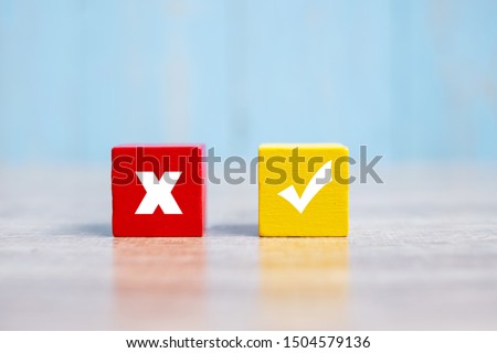 Wood cubes block with Wrong and Right symbol on table background