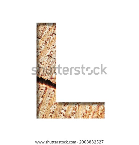 Wood cut font. The letter L cut out of paper on the background of a cut of a tree with cracks and shavings. Set of decorative natural alphabet fonts.