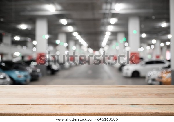 Wood desk\
empty and blur car parking\
background.