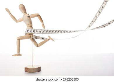 A wood doll run to the front with tape measure(tapeline) for health and diet isolated white background at the studio. - Powered by Shutterstock