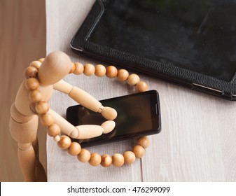 Wood doll using phone on wooden background. - Powered by Shutterstock