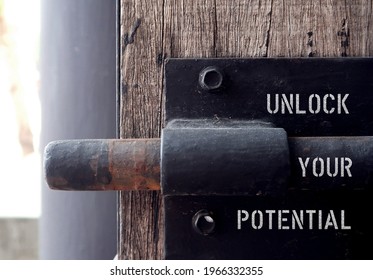 Wood door with steel old style lock, text inscription UNLOCK YOUR POTENTIAL ,concept of to unfold talents, when someone capable to do more, think less and act more, start to put dreams in practicality - Shutterstock ID 1966332355