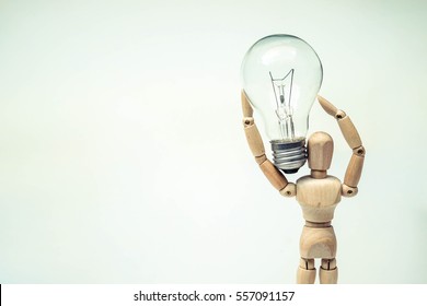 Wood Figure Mannequin carrying an incandescent light bulb / New idea concept - Powered by Shutterstock