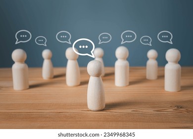 Wood figure with standing out from the crowd of different people, chatting concept, Wooden figurine with speech bubble, Unique human shape, Leadership,  Human resource.