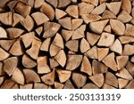 Wood for The Fire. Background of stacked chopped wood logs. Pile of wood logs ready for winter. Wooden stumps, firewood stacked in heap.