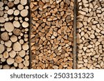 Wood for The Fire. Background of stacked chopped wood logs. Pile of wood logs ready for winter. Wooden stumps, firewood stacked in heap.