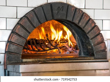 Wood Fire Pizza Oven With Flames And Brick Inside A Professional Restaurant Kitchen 