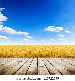 Wood Floor Over Yellow Wheat Field Under Nice Sunset Cloud Sky Background