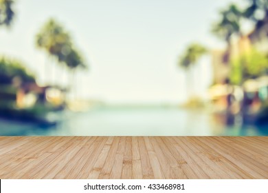 Wood floor texture with blur summer background tropical resort hotel with beach house swimming pool water and palm tree