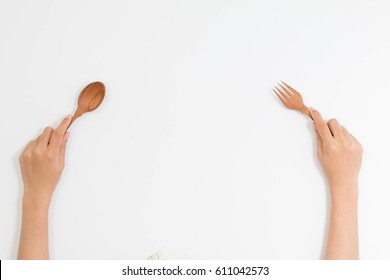 Wood Fork And Spoon In Woman Hand In Top View Isolated On White Background With Clipping Path