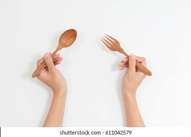 Wood Fork And Spoon In Woman Hand In Top View Isolated On White Background With Clipping Path