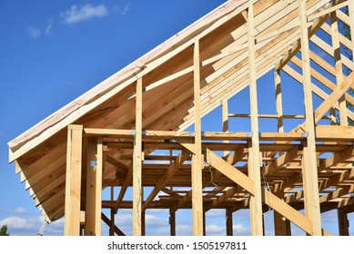 Wood Frame Residential Building Under Construction.Building Construction, Wood Framing Structure At New Property Development Site.new Home Currently Under Construction Against Blue Sky.mortgage, Loan.