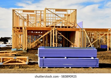 Wood Frame Two Story Residential Building Under Construction With Building Materials In Foreground.