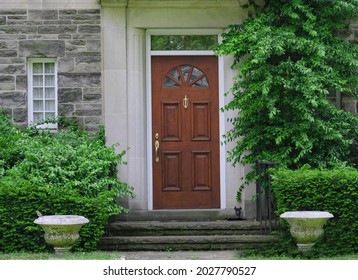 Wood Grain Front Door Of Old Stone House With Shrubbery