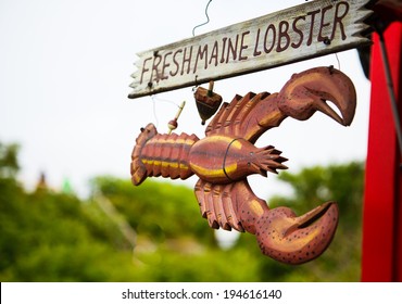 A wood hand painted and carved sign advertising fresh Maine lobster