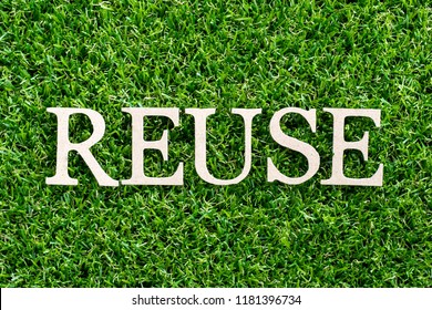 Wood letter in word reuse on artificial green grass background