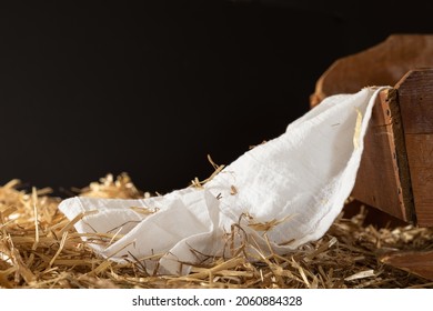 Wood manger or cradle with white linen and hay with a black background with copy space - Shutterstock ID 2060884328