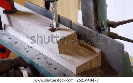 Wood mortising process using a mortising machine on a hardwood block in a woodworking workshop.