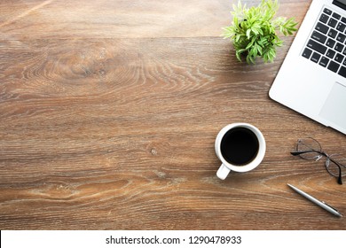 Wood Office Desk Table With Laptop, Cup Of Coffee And Supplies With Morning Sun Light. Top View With Copy Space, Flat Lay.