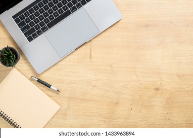 Wood Office Desk Table With Laptop Computer, Succulent Plant, Paper Notepad, Pen. Minimal Flat Lay Style Composition With Copy Space, Top View, Overhead. Business Woman Workspace Concept. 