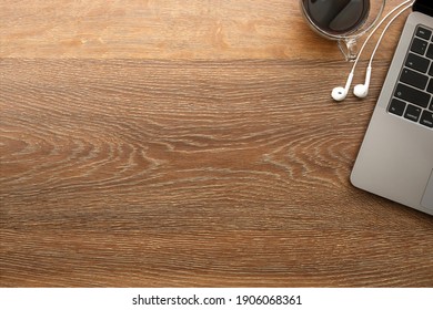 Wood Office Desk Table With Laptop Computer, Cup Of Coffee And Earphones. Top View With Copy Space, Flat Lay.