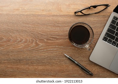 Wood Office Desk Table With Laptop Computer, Cup Of Coffee And Supplies. Top View With Copy Space, Flat Lay.