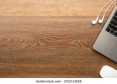 Wood Office Desk Table With Laptop Computer, Wireless Mouse And Earphones. Top View With Copy Space, Flat Lay.