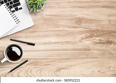 Wood office desk table with laptop, cup of coffee and supplies.   - Shutterstock ID 583952221