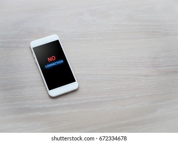 Wood Office Table With No Connection Message On Cell Phone Screen.