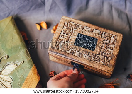 Wood on brown tablecloth, embroidered, vintage and elegant box, dried orange leaves, decoration