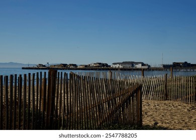 Wood picket fence along the shore in front of the pier - Powered by Shutterstock