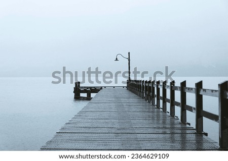 A wood pier against a scenic view in a foggy day