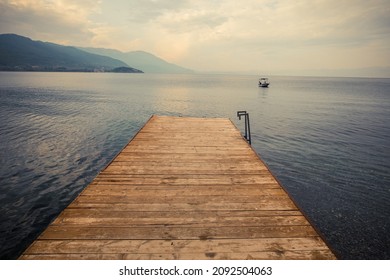 Wood pier pontoon on a lake and a boat.