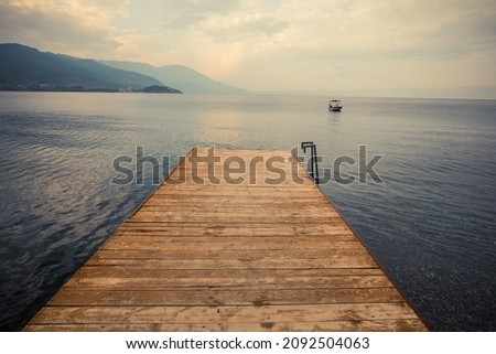 Wood pier pontoon on a lake and a boat. Stock foto © 