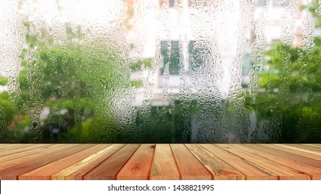 Wood Plank With Abstract Water Drop On Glass Background Of Glass Window Shop On A Rainy Day. Free Place For Creativity. Background.