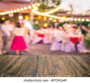 Wood Plank With Copy Space On Evening Outdoor Party Or Fair Festival With Blur Background.