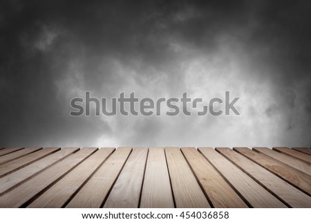 Wood platform and cloudy dark dramatic sky.