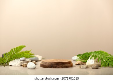 Wood podium with green leaves and natural stones. Abstract podium for organic cosmetic products. Natural stand for presentation and exhibitions. Front view - Shutterstock ID 2071901015