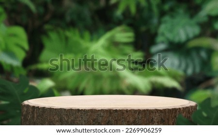Wood podium table top outdoors blur green monstera tropical forest plant nature background.Beauty cosmetic healthy natural product placement pedestal display,spring or summer jungle paradise.