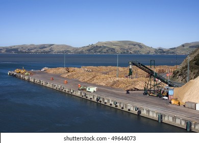 Wood Pulp And Logs On A Wharf Ready For Loading Onto A Ship