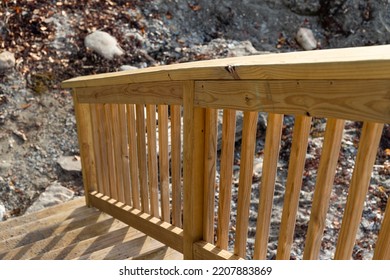 Wood railing going down to a rocky beach in Maine. - Shutterstock ID 2207883869