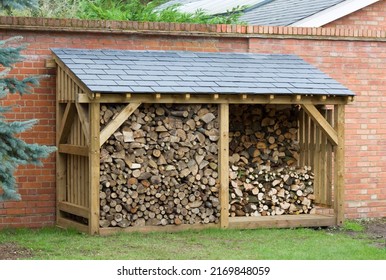 Wood shed, large log store filled with firewood, timber construction with a slate roof, UK