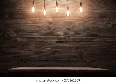 Wood shelf, grunge industrial interior with edison light bulb - Powered by Shutterstock
