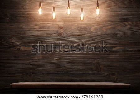 Wood shelf, grunge industrial interior with edison light bulb