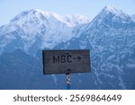 A wood sign lead to Machapuchare base camp in Nepal with view of Mt.Annapurna South (7,219 m) and Mt.Hiunchuli (6,441 m) in the background.