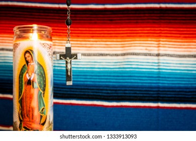 Wood And Silver Crucifix With Virgin Mary Prayer Candle To The Left, With Mexican Blanket As Backdrop. Cathoilc, Easter, Religion Concepts.