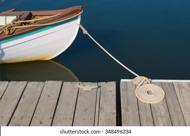 Wood Skiff Tied At Dock with Flemish Coil Beside Cleat - Powered by Shutterstock