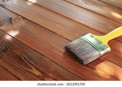 Wood Staining Diy. Brush. Painting Wooden Patio Deck With Protective Brown Oak Varnish. Outdoors. Decking Works. Copy Space