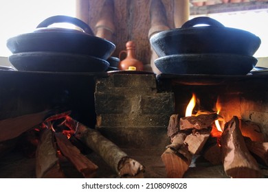 A Wood Stove With Clay Pots Cooking Over A Fire In A Countryside Kitchen